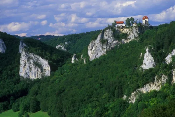 Bild mit Blick auf Schloss Bronnen umgeben von Felsen und bewaldeten Flächen
