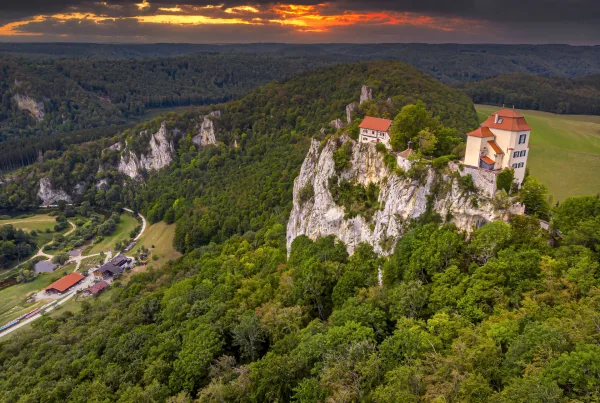 Bild von Schloss Bronnen von oben bei Abendstimmung mit schwarz rot verfärbtem Himmel