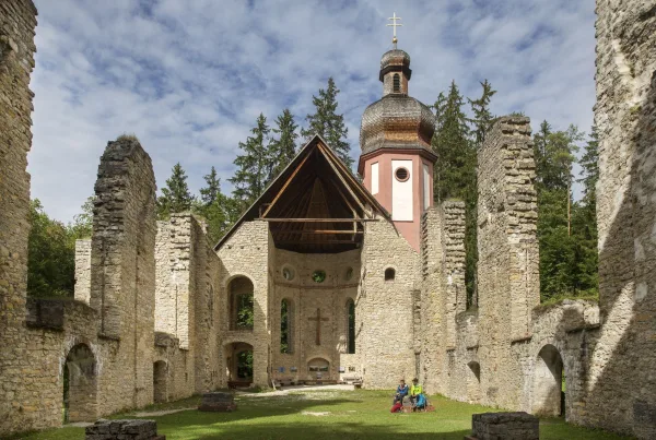 Bild von zwei Wanderern, die in einer Kirchenruine sitzen