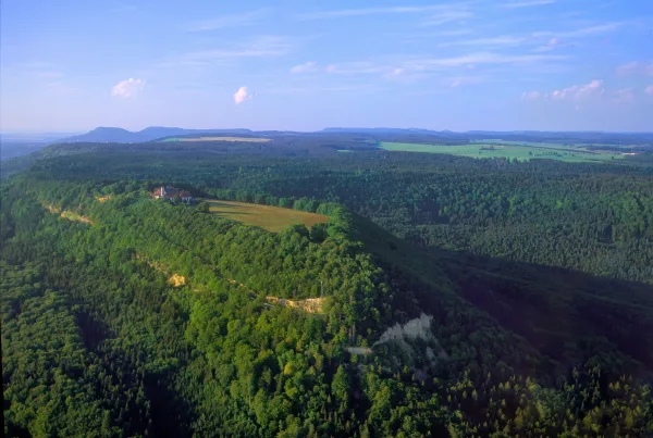 Luftaufnahme vom Dreifaltigkeitsberg in Richtung Lemberg fotografiert, ringsherum sind viele Waldflächen zu erkennen