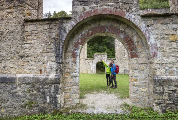 Bild von zwei Wanderern, die in einer Ruine stehen und sich gegenzeitig war zeigen