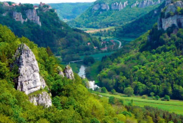 Bild von oben in ein Tal mit Häusern und bewaldet