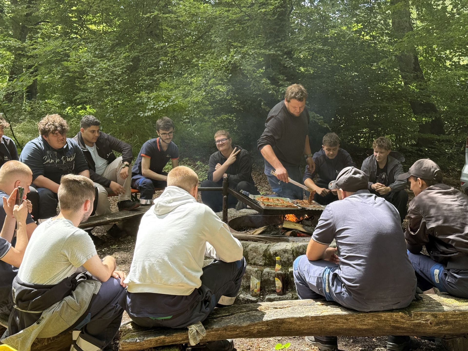 Lagerfeuer mit Würstchen, Gruppe junger Männer