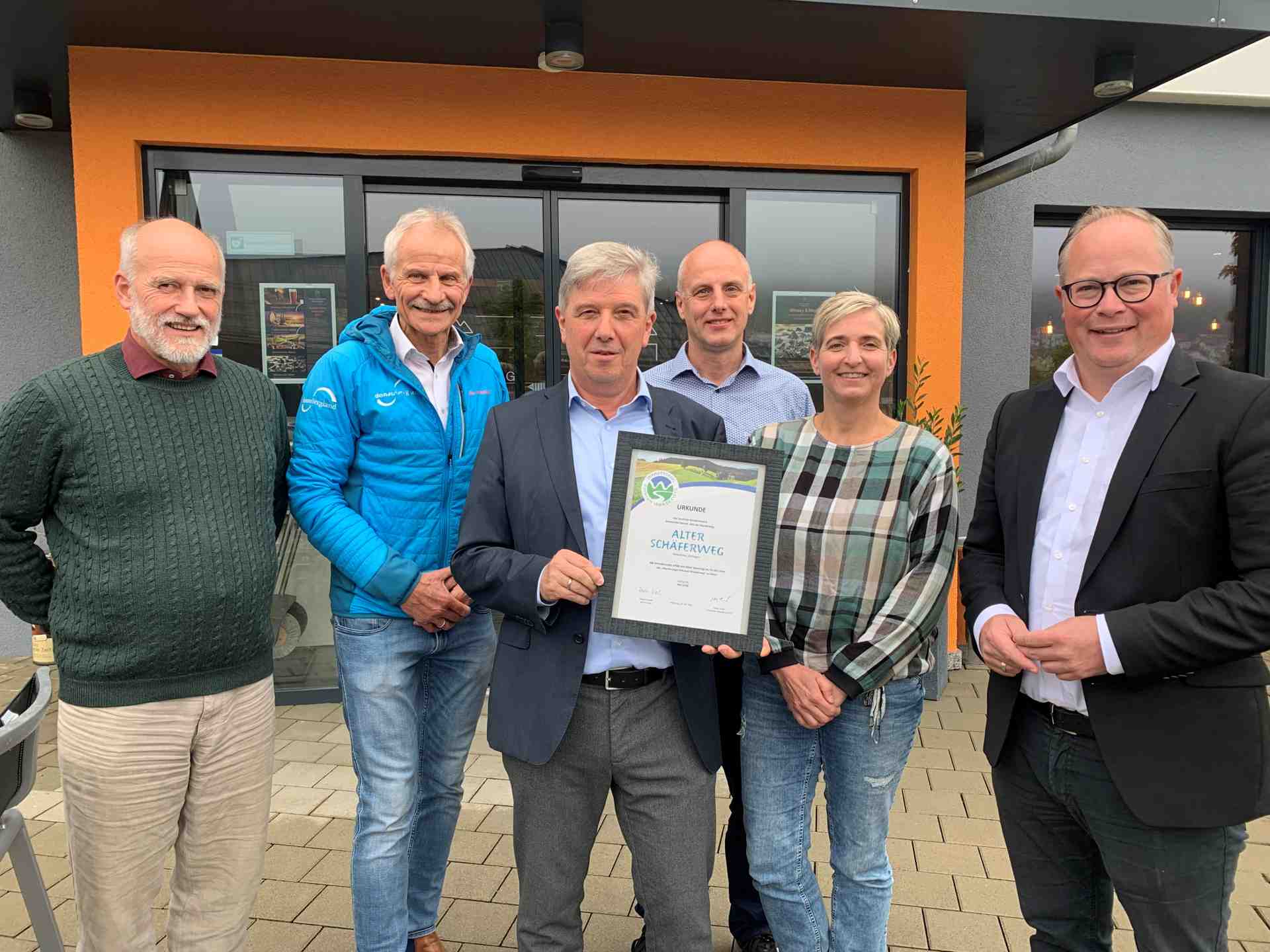 Fünf Männer und eine Frau präsentieren die Urkunde zur Auszeichnung als Premiumweg